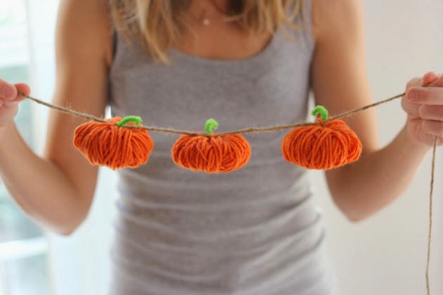 Hands holding a fall pumpkin garland