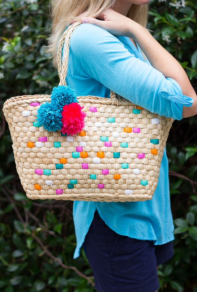 Straw handbag with online pom poms