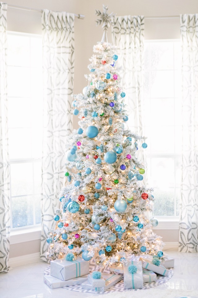 Flocked Christmas tree covered with jewel-toned ornaments