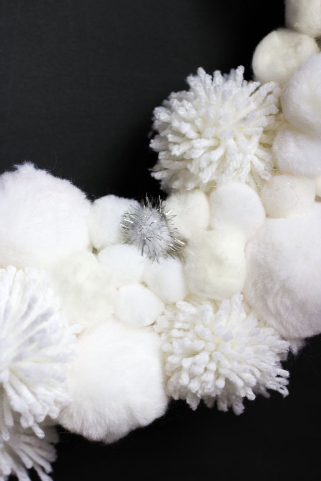 Love this DIY winter wreath bursting with pom-pom snowballs!