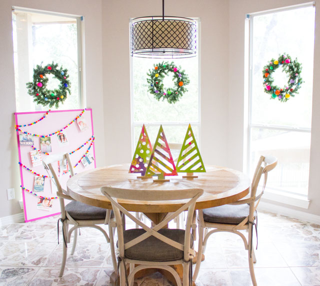 A colorful Christmas kitchen with pom-pom wreaths in the windows!