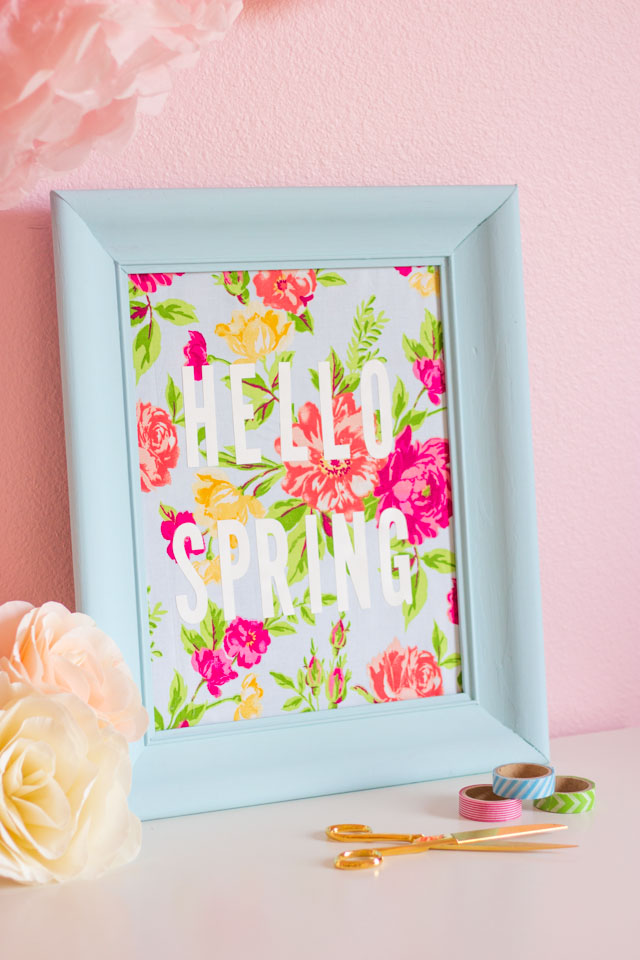 Such a fun thrift store makeover! Transform an old picture frame into this colorful Hello Spring fabric art!