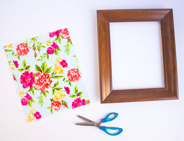 Such a fun thrift store makeover! Transform an old picture frame into this colorful Hello Spring fabric art!