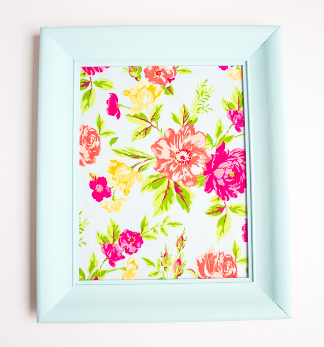 Such a fun thrift store makeover! Transform an old picture frame into this colorful Hello Spring fabric art!