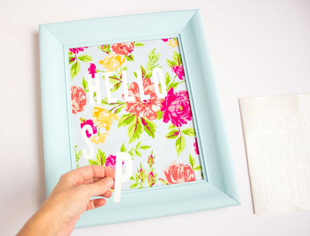 Such a fun thrift store makeover! Transform an old picture frame into this colorful Hello Spring fabric art!