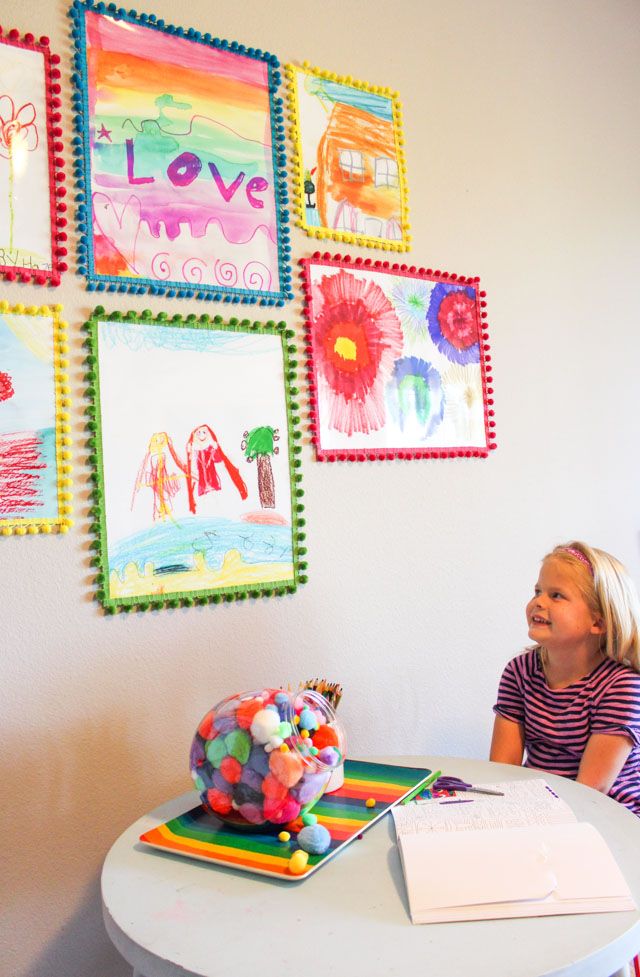 Turn kids art into colorful posters with pom-pom trim frames!