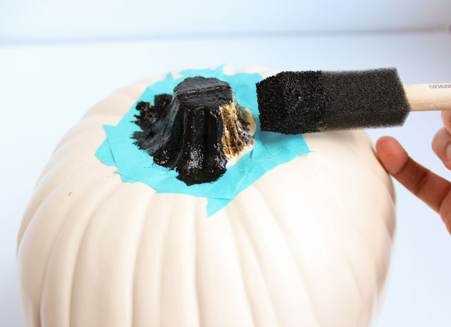 Make these DIY black flower pumpkins with dollar store flowers. The perfect mix of pretty and spooky for Halloween!