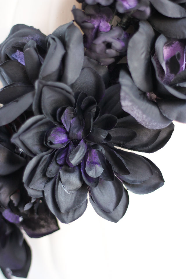 Make these DIY black flower pumpkins with dollar store flowers. The perfect mix of pretty and spooky for Halloween!