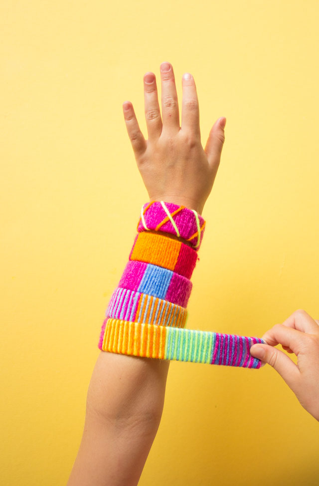 Make the coolest slap bracelets by wrapping them with yarn! #slapbracelets #kidscrafts #80scrafts #yarncrafts