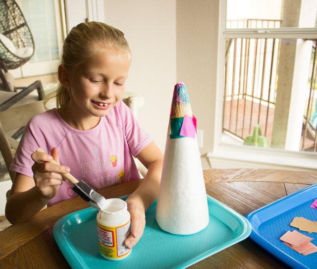 Turn foam cones into Christmas trees with tissue paper squares! #conetrees #christmastreecraft #christmascraft #foamconecraft #kidschristmascraft #modpodgecraft