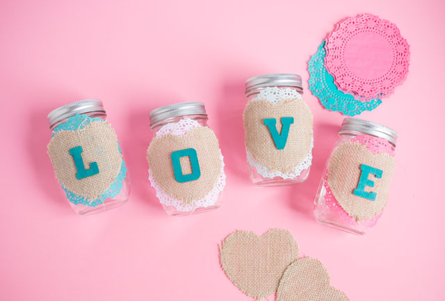These mason jars filled with doily flowers are a pretty DIY Valentine's Day decoration or centerpiece! #valentinecrafts #valentinescrafts #masonjarcrafts #doilycrafts #doilyflowers #paperflowers #valentinesdaycrafts