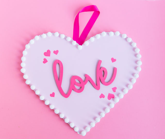 Make this pretty wood heart love decor for Valentine's Day! #woodheart #heartdecor #valentinescrafts #valentinesdecor #craftcuts #lovesign