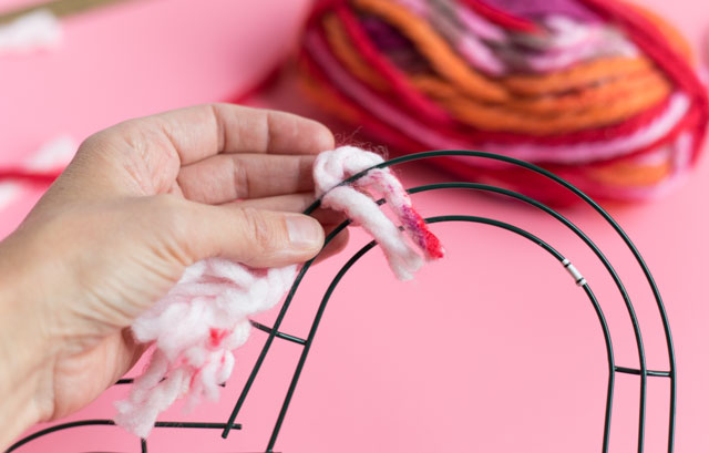 Simple yarn heart wreath - perfect Valentine's Day decor idea! #valentinesdaycrafts #valentinecrafts #heartcrafts #heartwreath #yarncrafts #yarnwreath