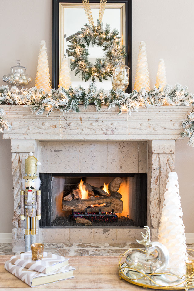 Silver and gold Christmas decorations on fireplace mantel