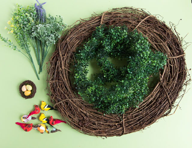 Make a beautiful spring wreath with faux birds, greenery, and nature elements. #birdwreath #springwreath #naturecrafts #birdcrafts