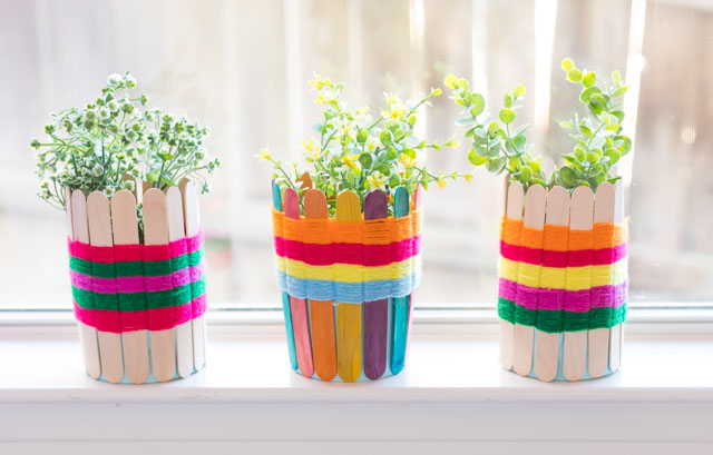 Use popsicle sticks and yarn to make these pretty woven baskets. Such a fun kids craft! #yarncrafts #kidscrafts #popsiclestickcrafts #popsiclestickweaving #kidsweaving