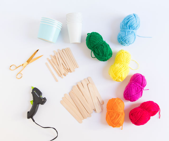 Use popsicle sticks and yarn to make these pretty woven baskets. Such a fun kids craft! #yarncrafts #kidscrafts #popsiclestickcrafts #popsiclestickweaving #kidsweaving