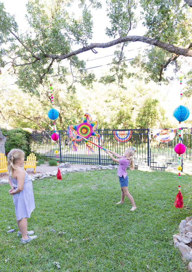 Colorful piñata and tassels hung from trees