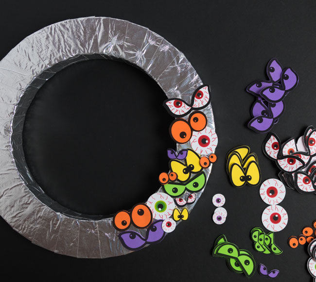 Adding eyeball stickers to wreath form