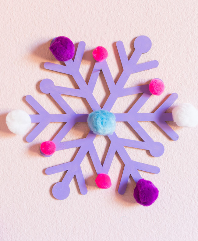 Giant wood snowflake with paint and pom-poms