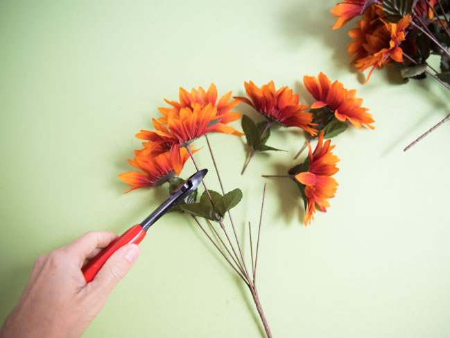 Clipping artificial flowers from their stems with wire cutters