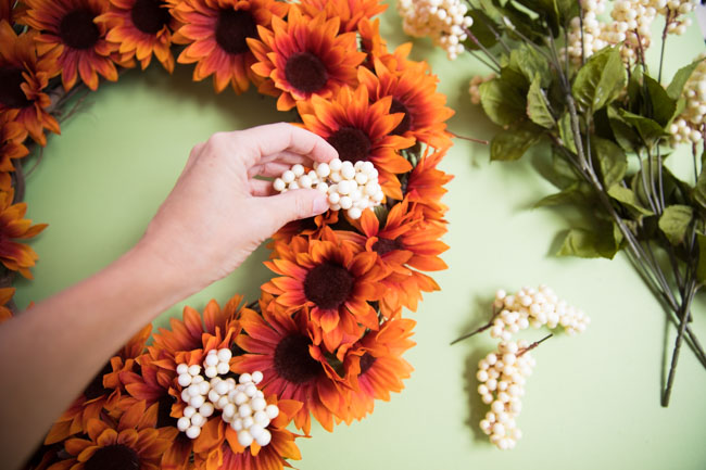 Adding berries to fall wreath