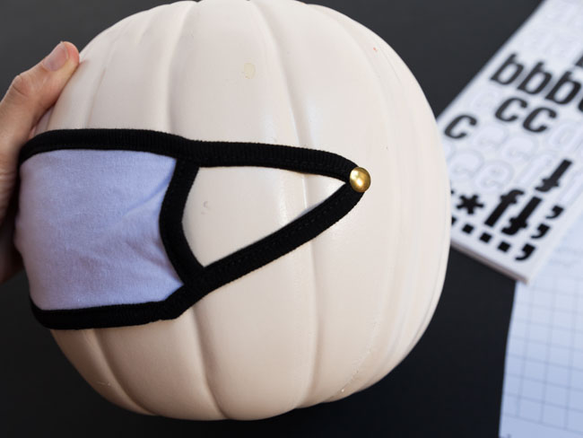 Decorating a pumpkin with a face mask