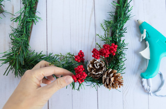 Making a DIY Christmas picture frame with pinecones and berries